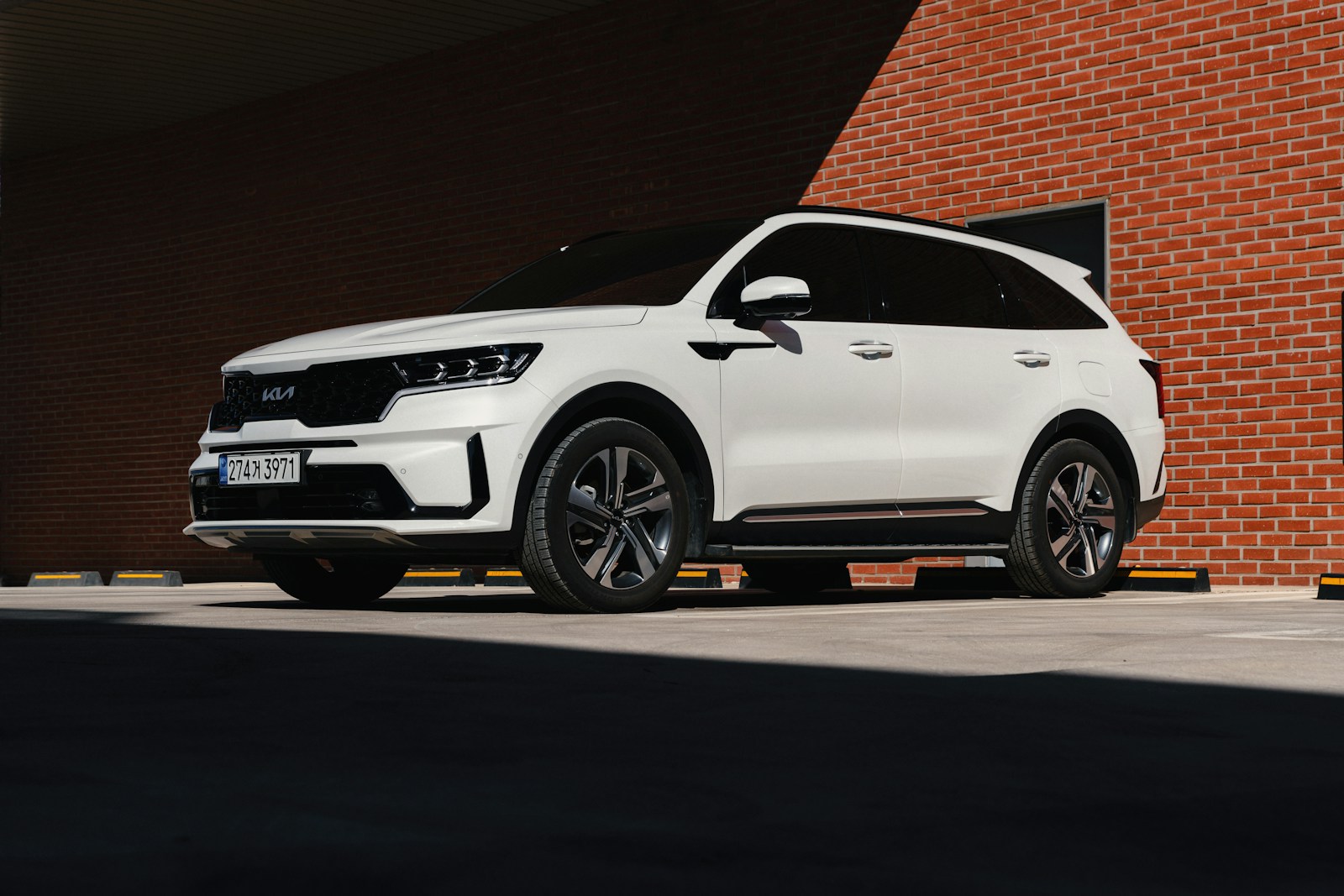 a white suv parked in front of a brick building