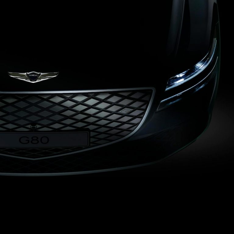 Close-up of Genesis G80 electric car showcasing its distinctive front grille and modern design.