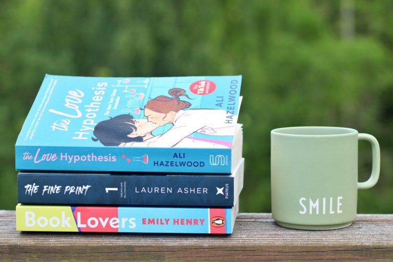 a stack of books sitting next to a coffee mug